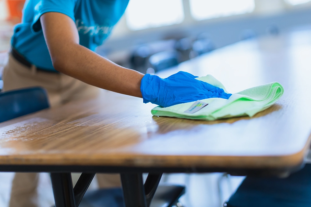 team member cleaning a school cafeteria